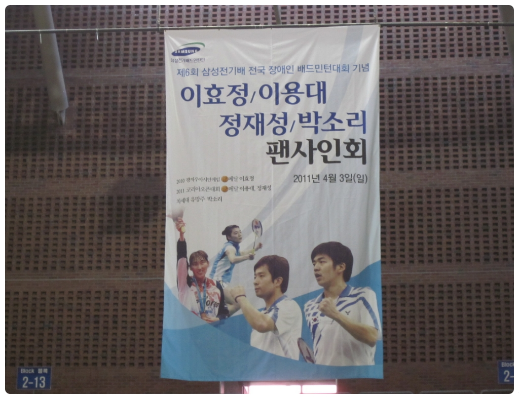 배드민턴 코트에서 스매시를 시도하는 선수 모습